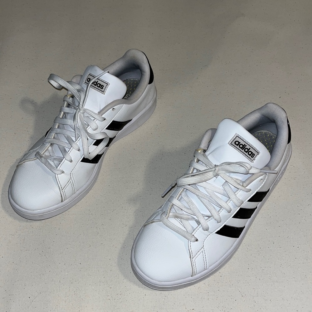 Gently used, white adidas tennis shoes.